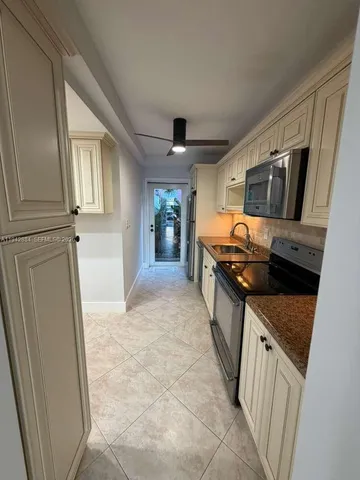 a kitchen with granite countertop a sink stove and refrigerator