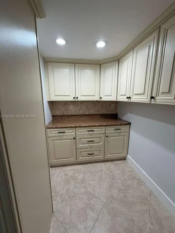 a view of kitchen with granite countertop cabinets and sink