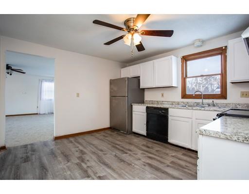 152 Starling Road Springfield, MA 01119 - Photo 7 of 28 a kitchen with granite countertop a refrigerator a sink dishwasher a stove and white cabinets with wooden floor