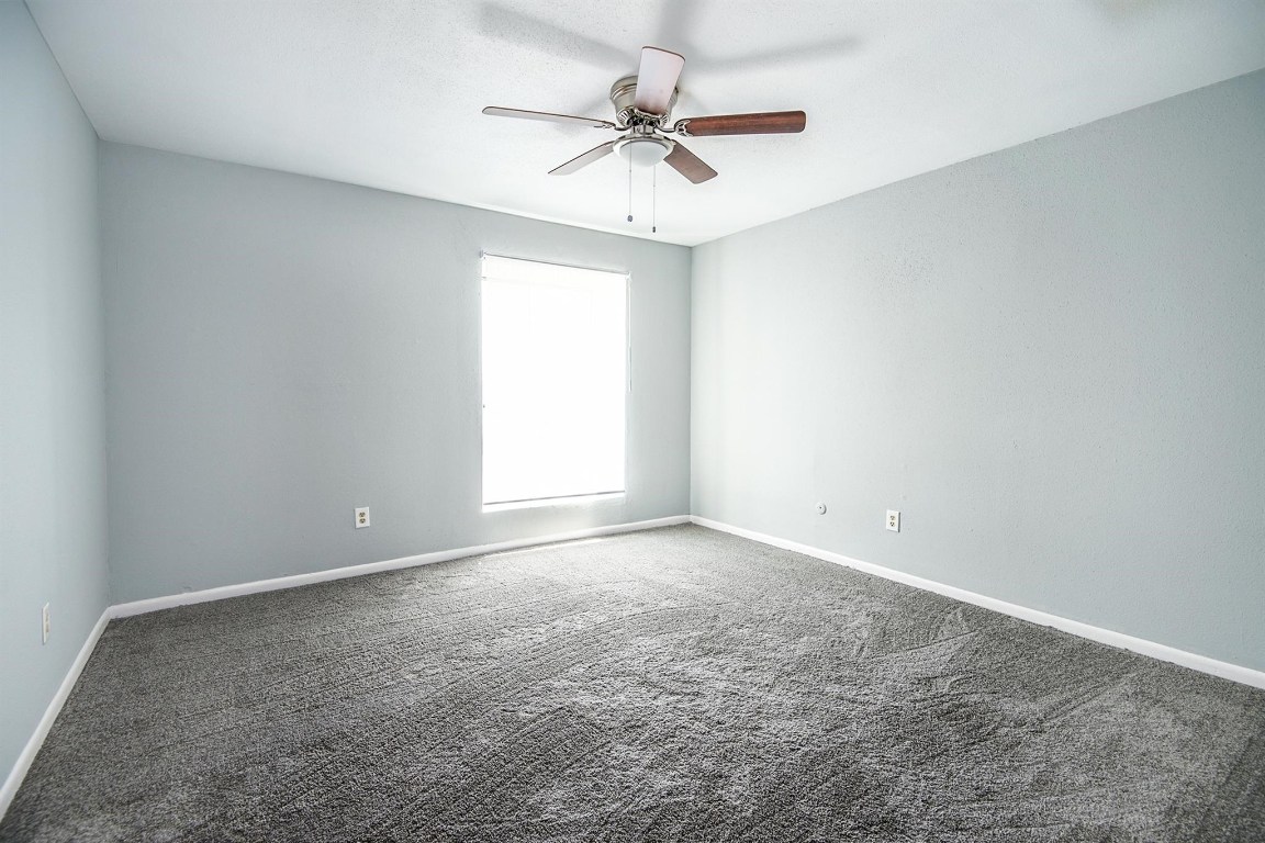 3085 Walnut Bend Lane, Unit 35 Houston, TX 77042 - Photo 12 of 23 an empty room with a ceiling fan and a window