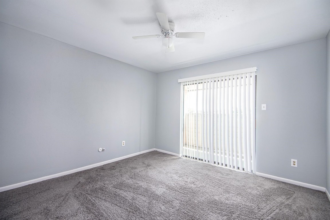 3085 Walnut Bend Lane, Unit 35 Houston, TX 77042 - Photo 9 of 23 an empty room with a window and a ceiling fan