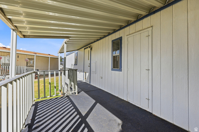 150 West 7500th South, Unit 55 Midvale, UT 84047 - Photo 27 of 28 Covered exterior walkway featuring a metal roof, white siding, and blue trim accents