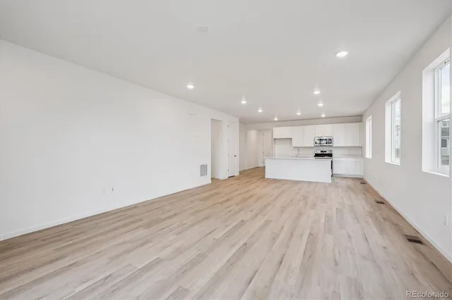 a view of kitchen with wooden floor and electronic appliances