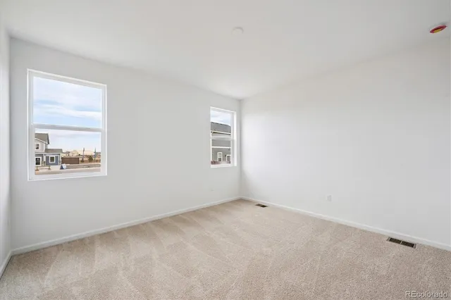 an empty room with windows and closet