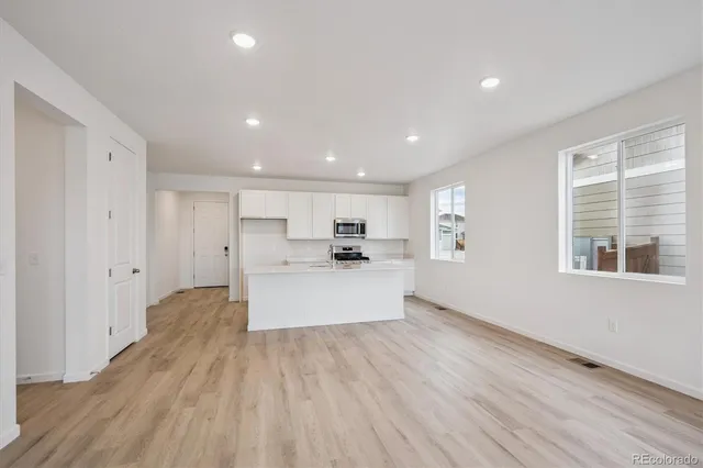 a kitchen with stainless steel appliances granite countertop a sink stove and microwave