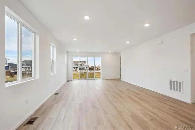 a view of empty room with wooden floor and window