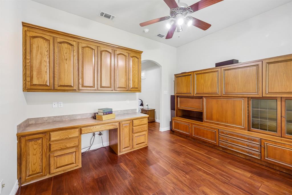 5409 Wedgefield Road Granbury, TX 76049 - Photo 24 of 39 Wood-finish flooring, built-in desk, extensive built-in cabinetry, ceiling fan with integrated lighting