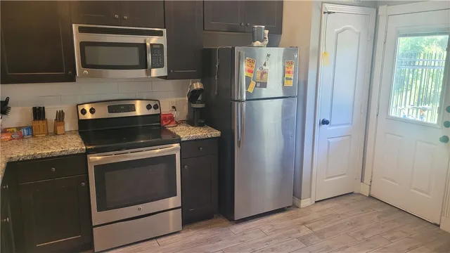 a kitchen with stainless steel appliances granite countertop a refrigerator and a sink