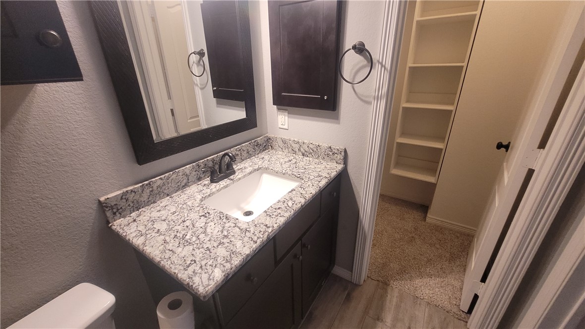 301 Southwest Parkway, Unit 304 College Station, TX 77840 - Photo 8 of 12 a bathroom with a granite countertop sink and a mirror