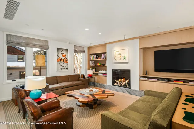 a living room with furniture a flat screen tv and a fireplace