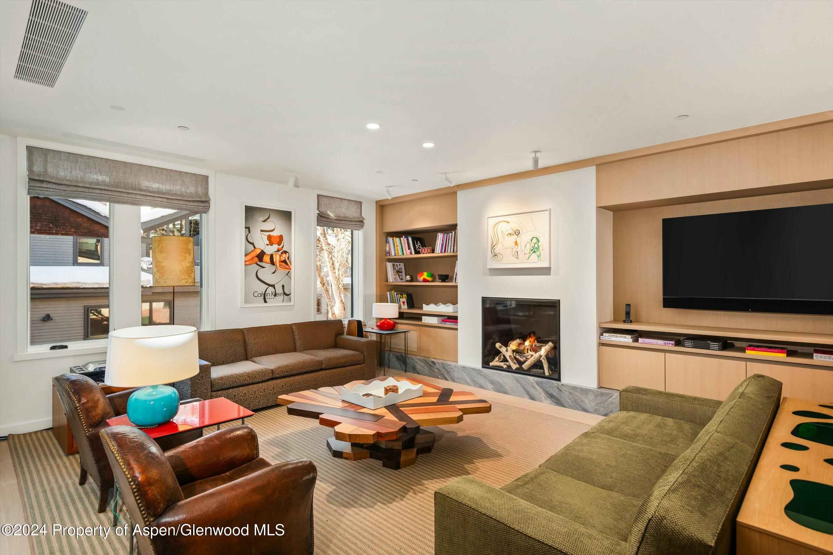 a living room with furniture a flat screen tv and a fireplace