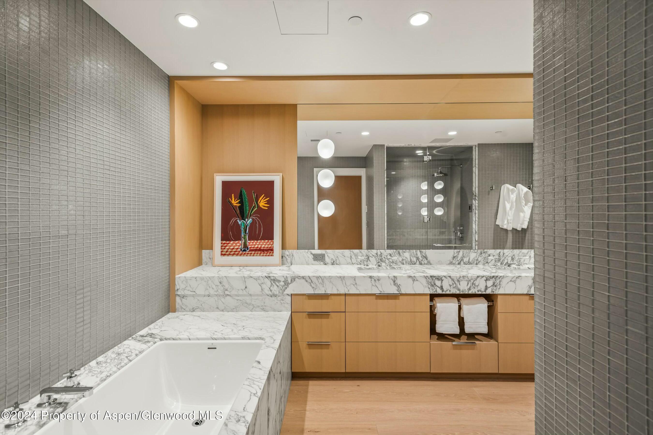 233 East Cooper Avenue, Unit 207 Aspen, CO 81611 - Photo 22 of 45 a bathroom with a granite countertop sink a large mirror and a shower
