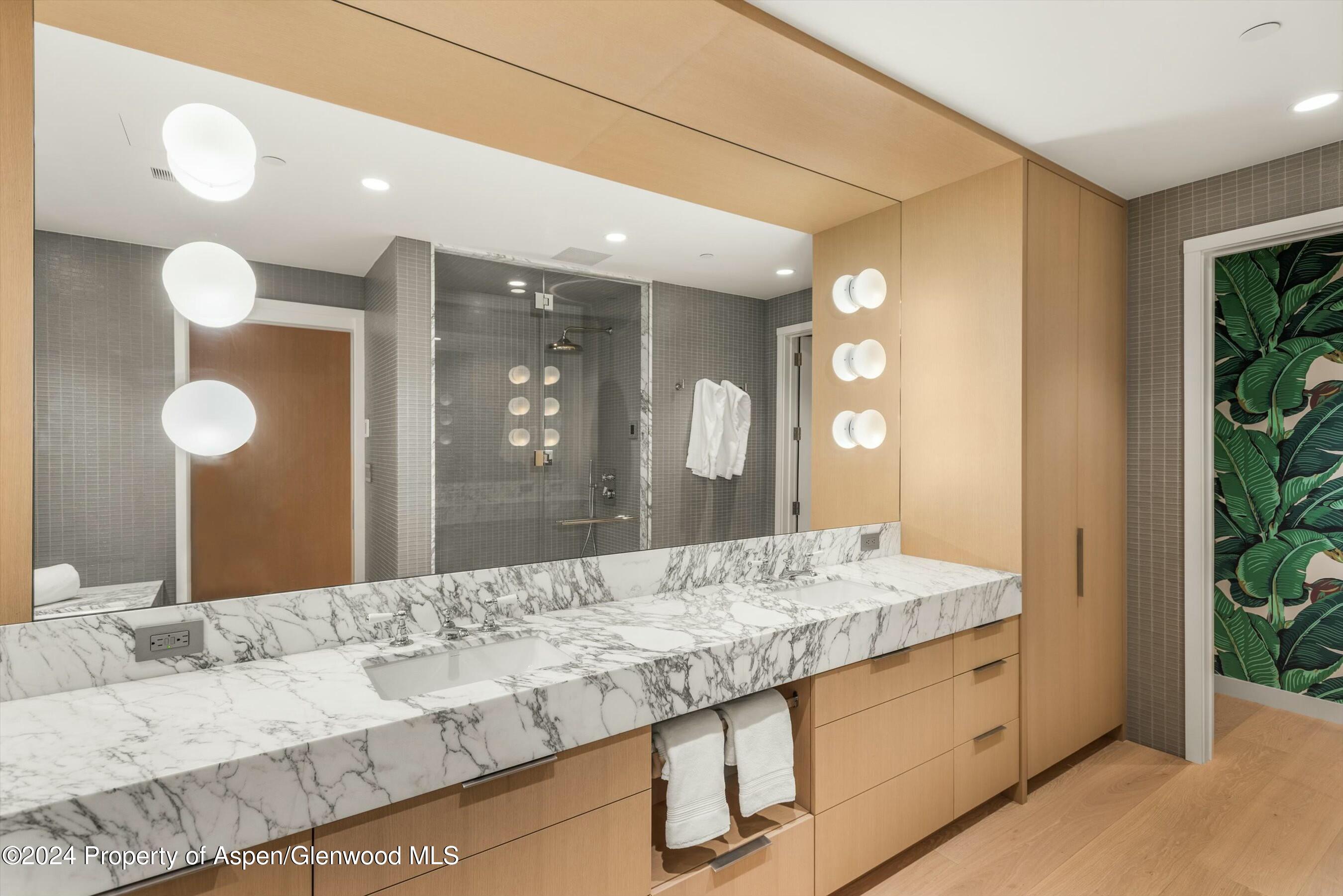 233 East Cooper Avenue, Unit 207 Aspen, CO 81611 - Photo 24 of 45 a bathroom with a granite countertop sink and a mirror