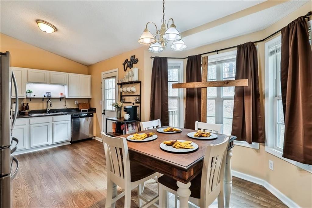 385 Prometheous Way Rockmart, GA 30153 - Photo 8 of 27 a open dining room with stainless steel appliances kitchen island granite countertop a dining table and chairs with wooden floor