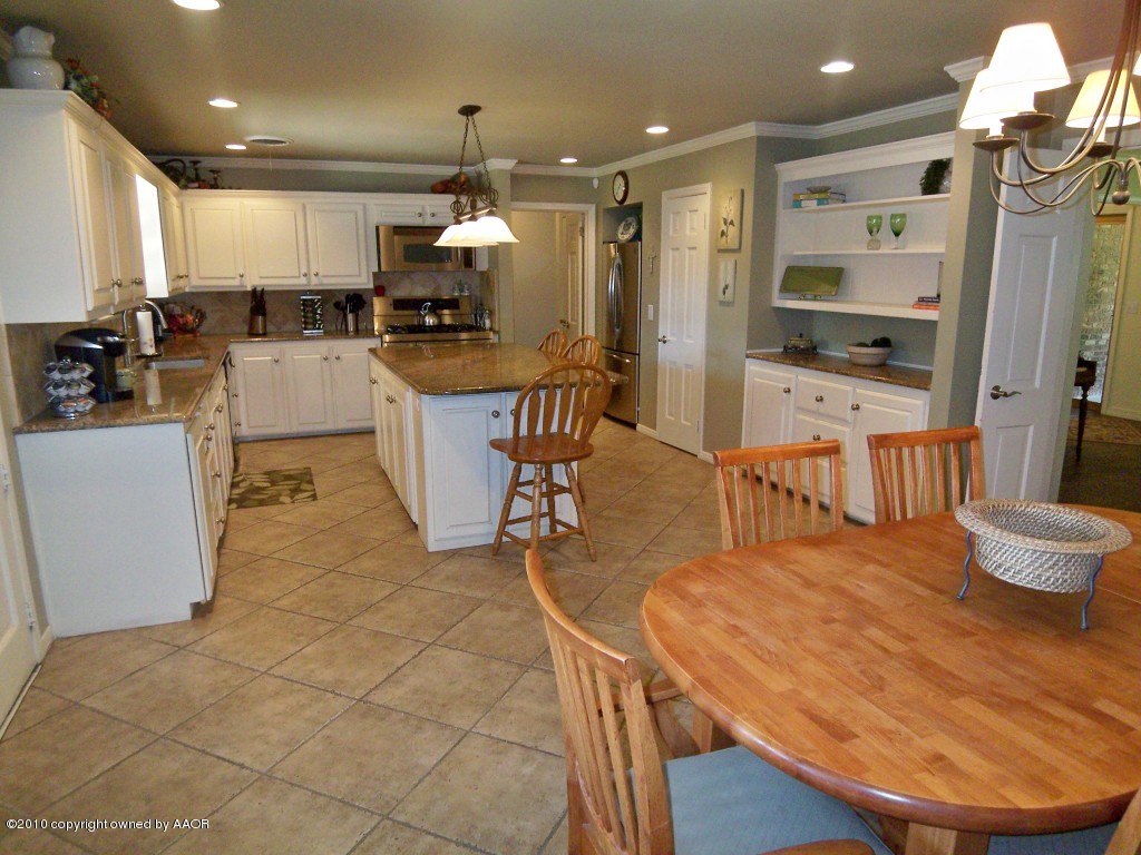 6301 Elmhurst Road Amarillo, TX 79106 - Photo 6 of 20 a kitchen with stainless steel appliances kitchen island granite countertop a table chairs and a refrigerator