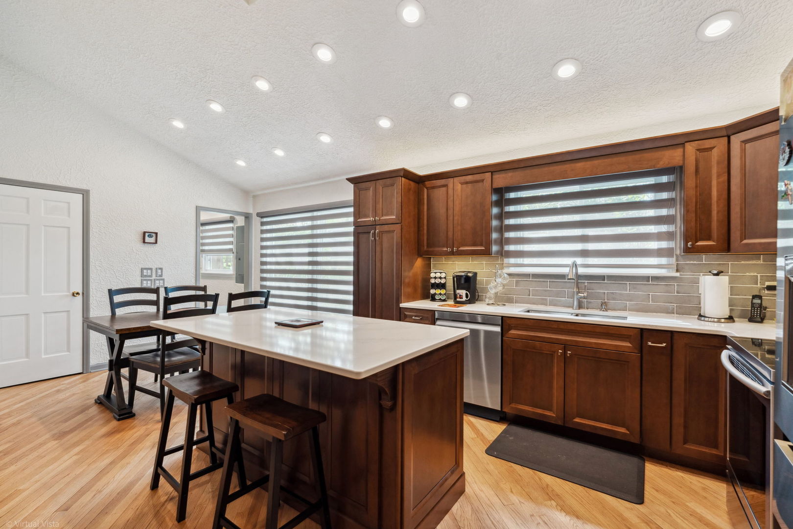396 Jervey Lane Bartlett, IL 60103 - Photo 18 of 39 a kitchen with stainless steel appliances granite countertop a table chairs sink and cabinets
