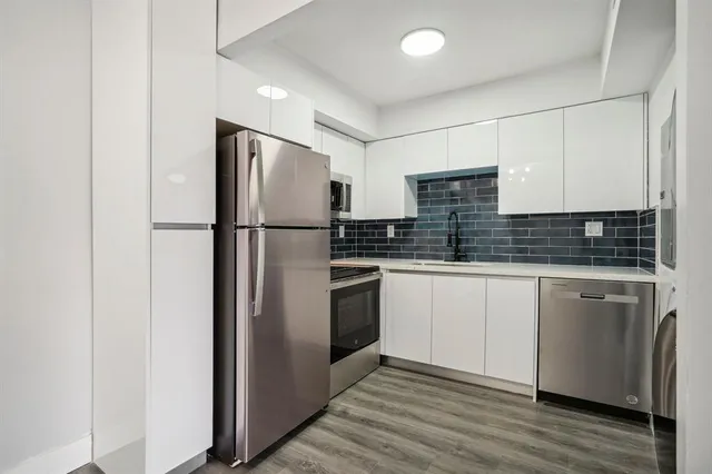 a kitchen with stainless steel appliances a refrigerator sink and cabinets