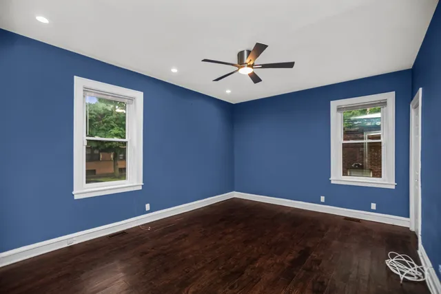 a view of a big room with wooden floor and windows
