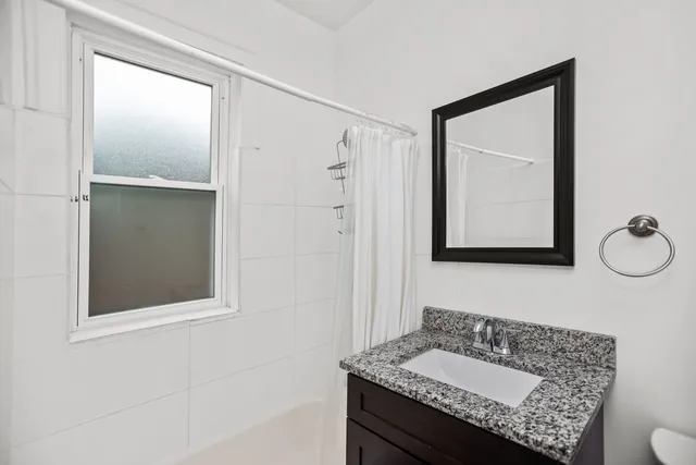 a bathroom with a granite countertop sink vanity and mirror