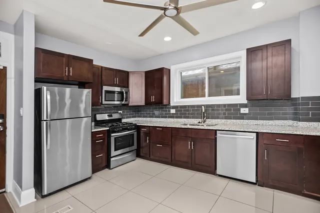 a kitchen with stainless steel appliances granite countertop a refrigerator and a sink