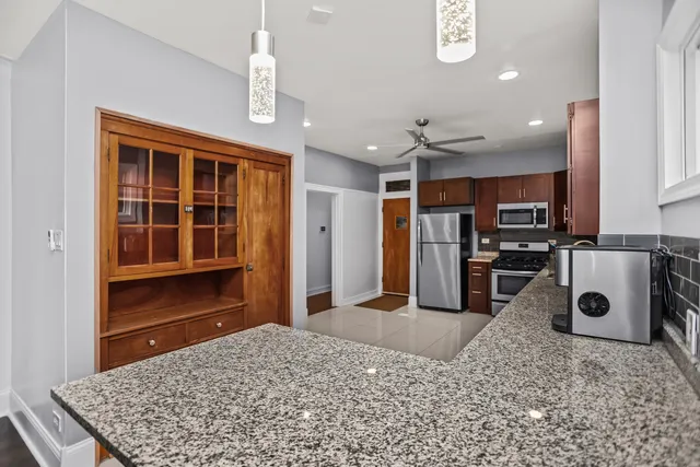 a kitchen with stainless steel appliances granite countertop a stove and a refrigerator
