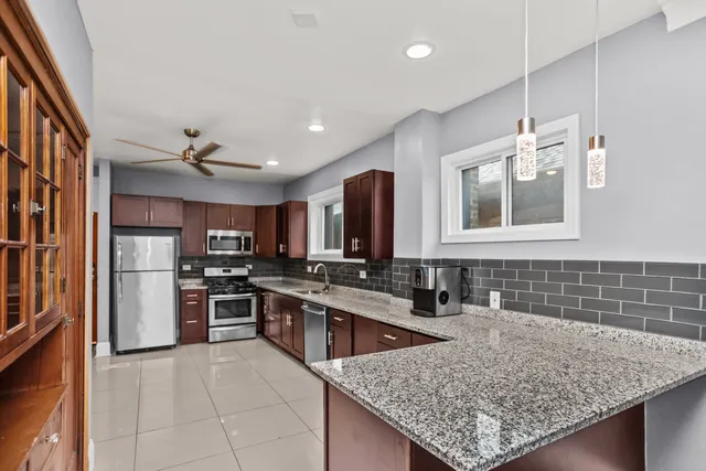 a kitchen with stainless steel appliances granite countertop a sink stove and refrigerator