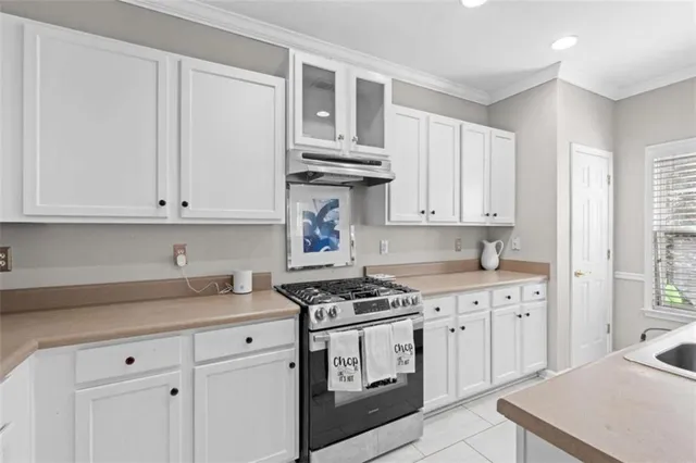 a kitchen with granite countertop white cabinets and white appliances