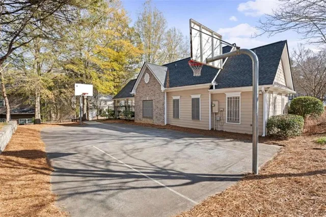 a view of a white house next to a yard with potted plants
