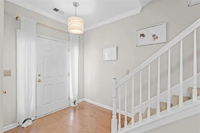 a view of staircase with white walls and chandelier
