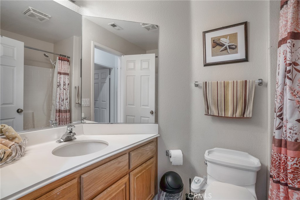 8946 Burlington Circle Riverside, CA 92508 - Photo 16 of 26 a bathroom with a toilet sink and mirror