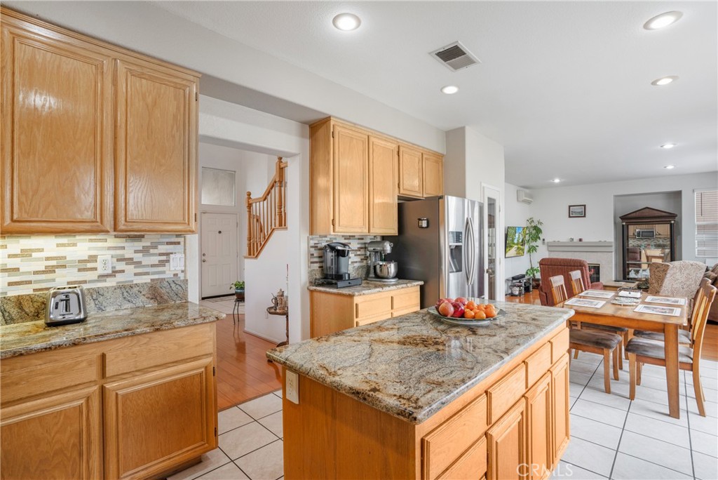 8946 Burlington Circle Riverside, CA 92508 - Photo 5 of 26 a kitchen with stainless steel appliances granite countertop wooden cabinets and a refrigerator