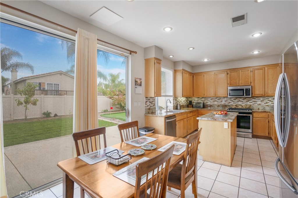 8946 Burlington Circle Riverside, CA 92508 - Photo 6 of 26 a kitchen with a table chairs microwave and cabinets
