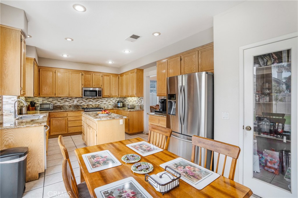 8946 Burlington Circle Riverside, CA 92508 - Photo 7 of 26 a kitchen with a refrigerator sink and cabinets