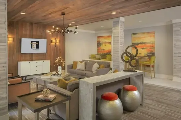 a living room with furniture a chandelier and a floor to ceiling window