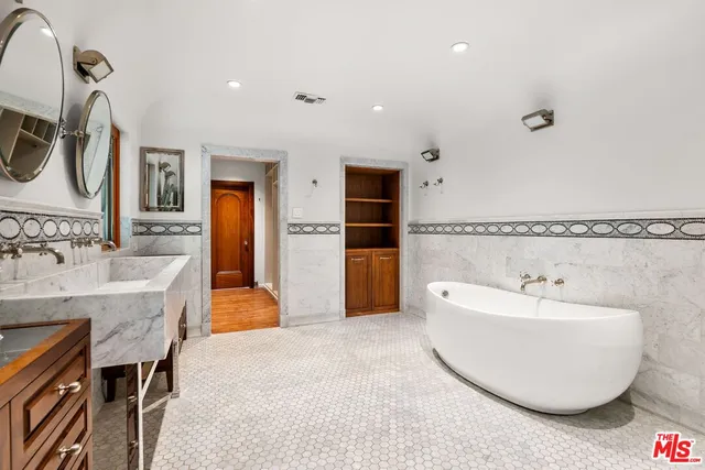 a spacious bathroom with a double vanity sink tub and mirror