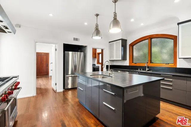 a kitchen with stainless steel appliances granite countertop a sink a stove and refrigerator