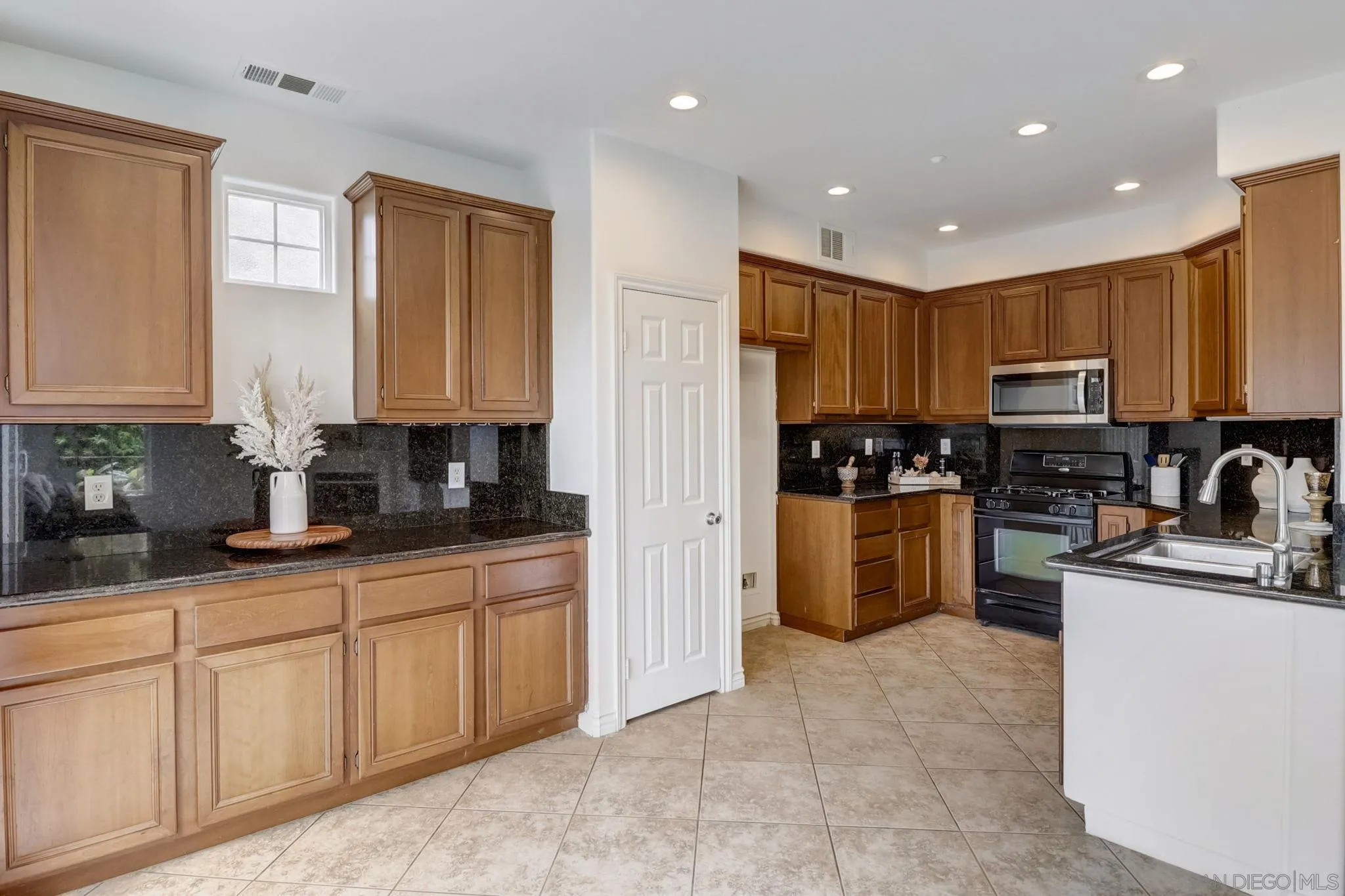 648 Beach Street Encinitas, CA 92024 - Photo 11 of 31 a kitchen with kitchen island granite countertop stainless steel appliances cabinets a sink and a counter top space