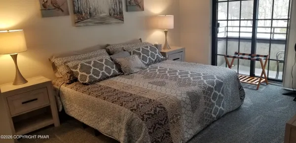a bed sitting in a bedroom next to a lamp