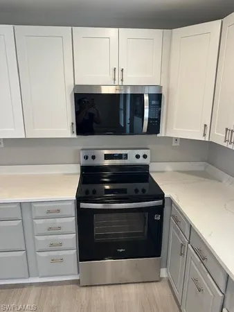 a kitchen with granite countertop white cabinets and white appliances