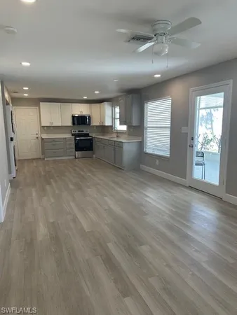 a view of a kitchen with a sink cabinets and wooden floor