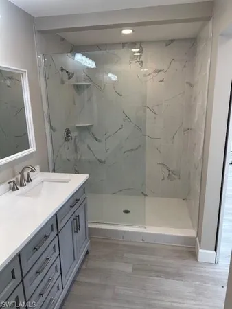 a bathroom with a bathtub a mirror a sink and vanity