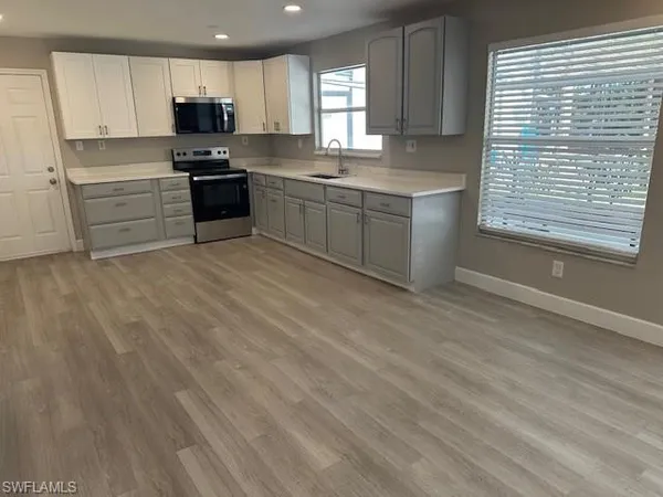 a kitchen with stainless steel appliances granite countertop a stove a sink and a microwave