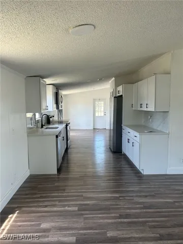 a kitchen with stainless steel appliances kitchen island granite countertop a stove a sink and white cabinets