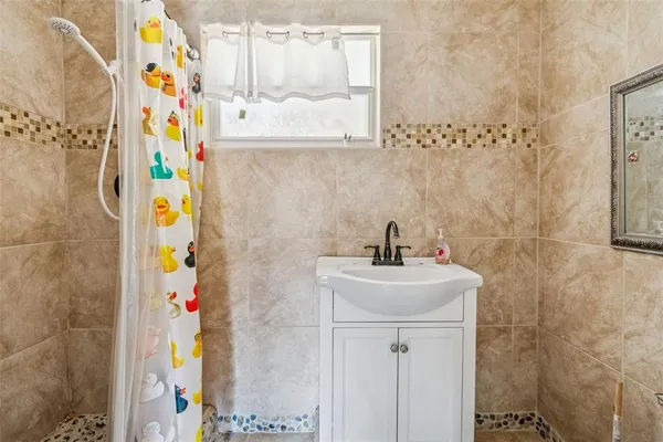 a bathroom with a sink a mirror and painting on the wall