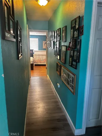 a hallway with seating area and hardwood floor