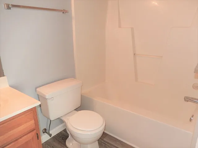 a white toilet sitting next to a shower