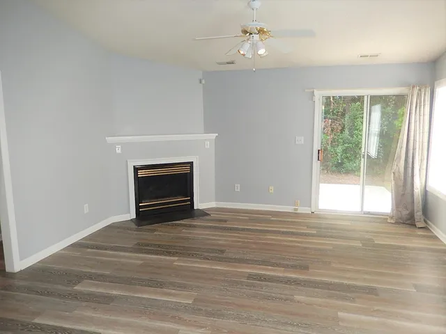 a view of livingroom with furniture wooden floor fireplace and a window