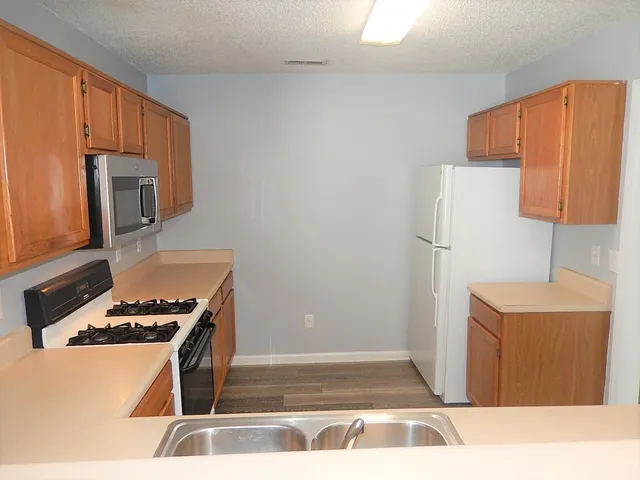 a kitchen with stainless steel appliances a refrigerator and a stove top oven