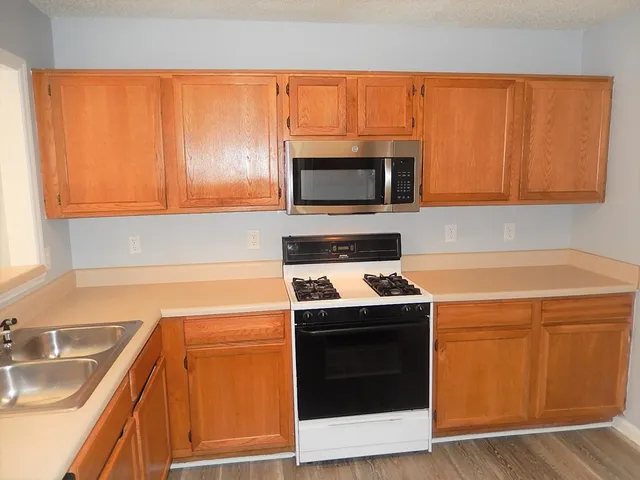 a kitchen with a sink stove and microwave