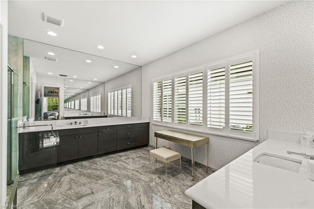 12033 Azalea Way Naples, FL 34120 - Photo 14 of 46 Primary suite bathroom with sleek cabinetry, plantation shutters, dual vanities, walk-in shower, water closet.